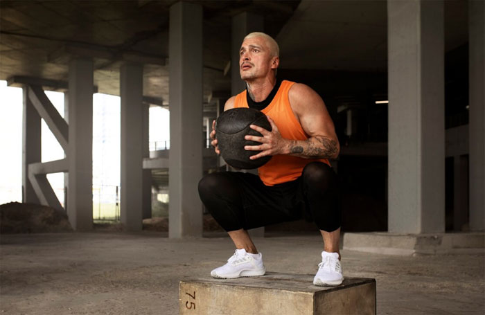 Man squatting at gym