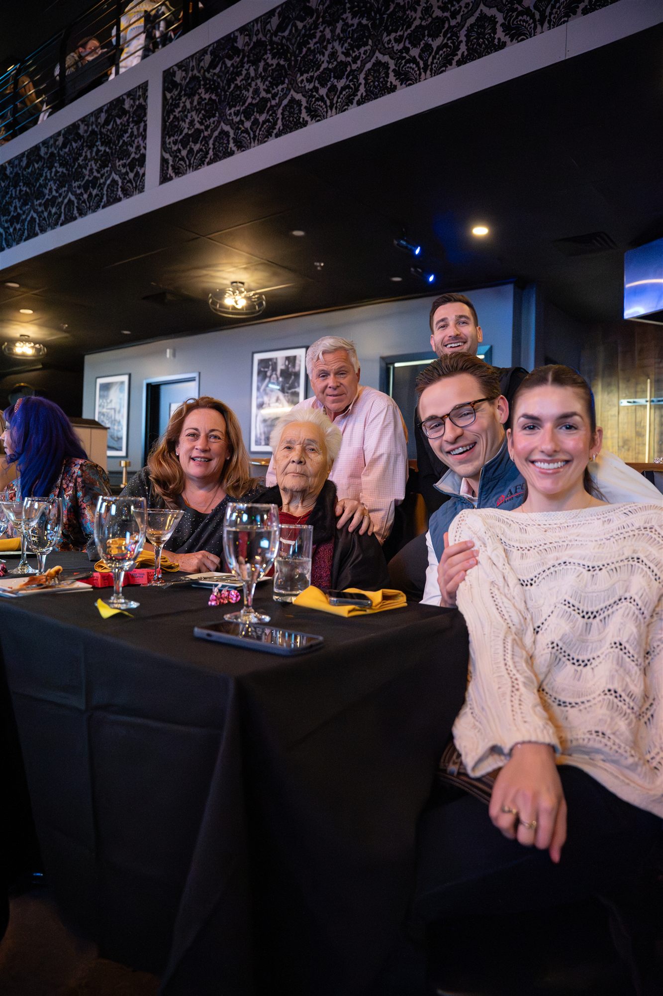 Three generations of a smiling family gathered around a dinner table
