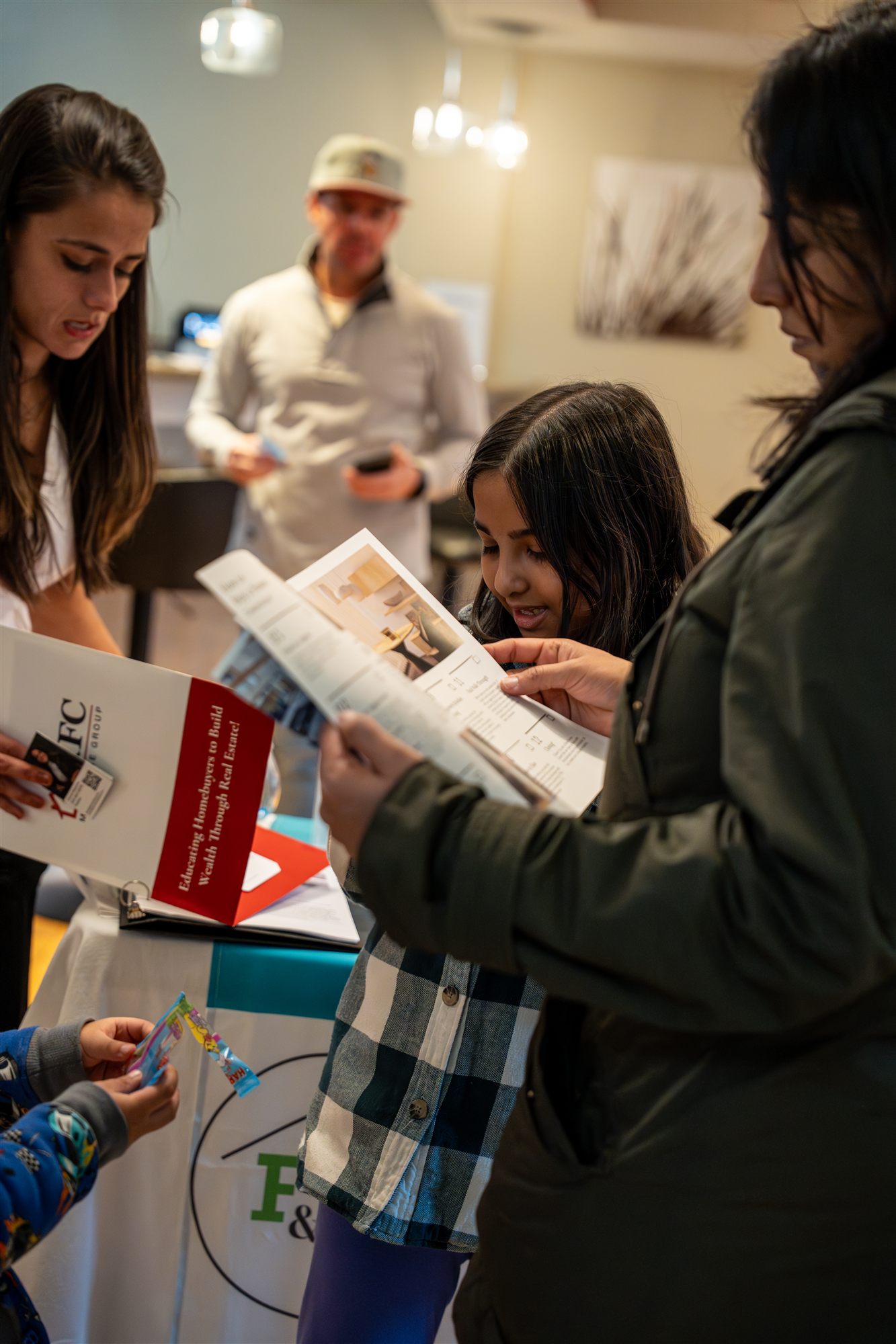 Mother and kids reading an AFC homebuyer folder together at the seminar
