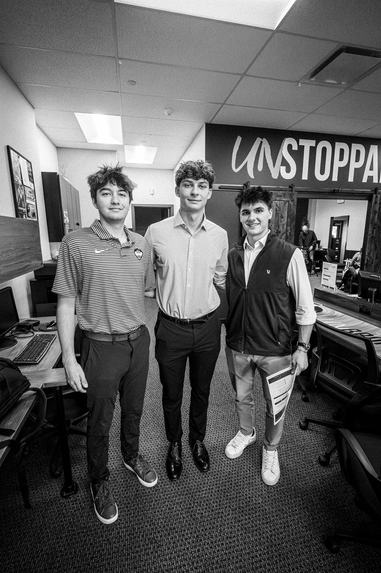 Three AFC interns under the UNSTOPPABLE wall in black and white