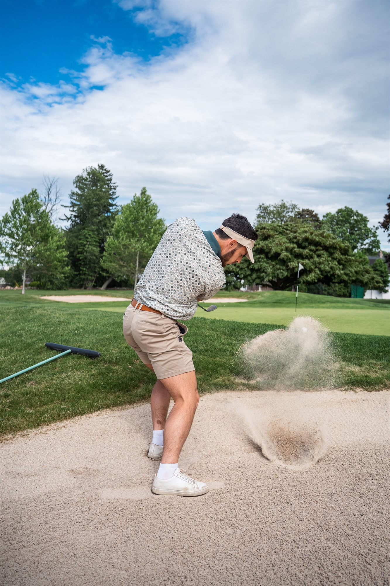 AFC team member blasting out of a golf bunker