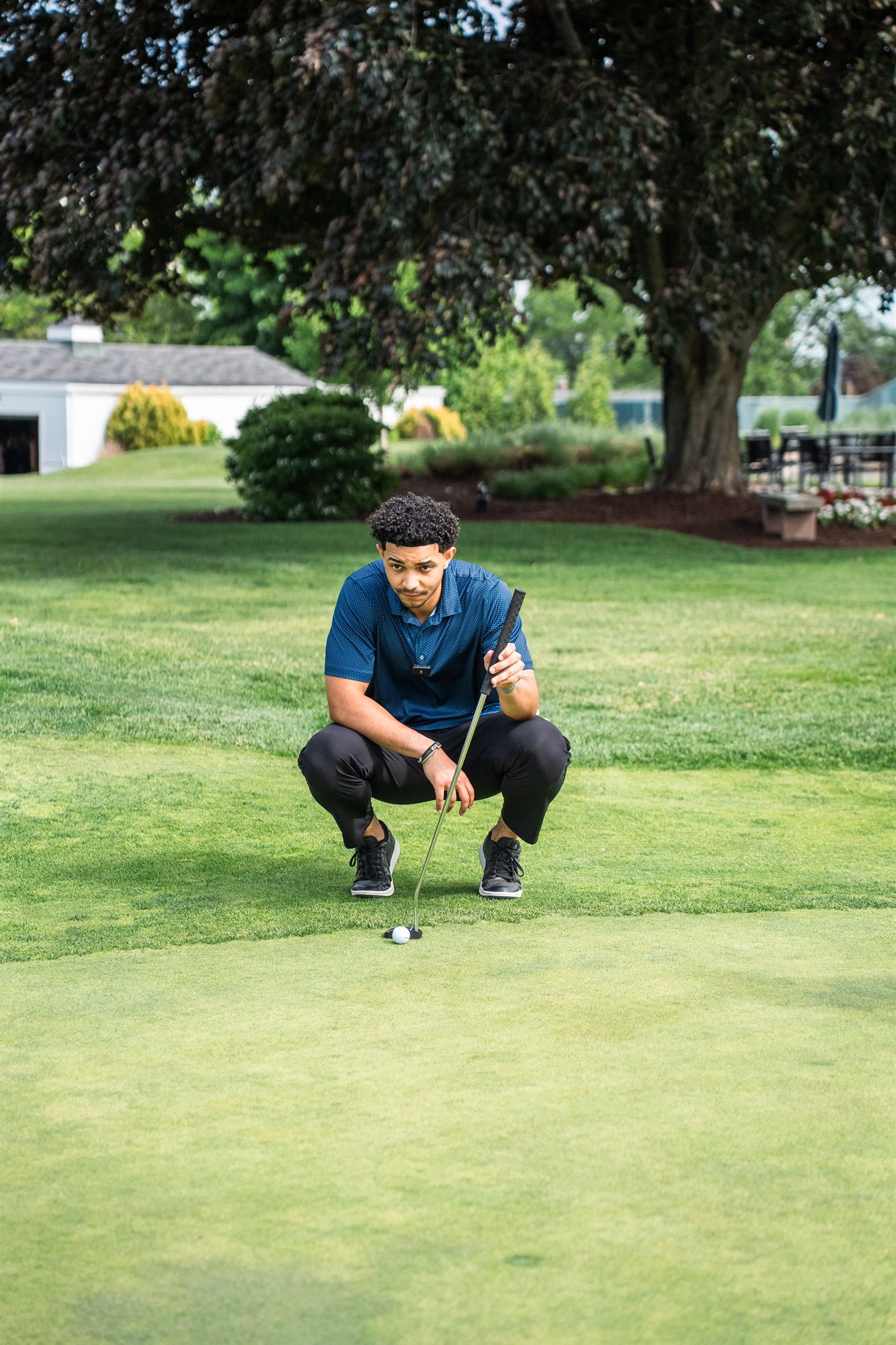 AFC team member reading a putt on the green