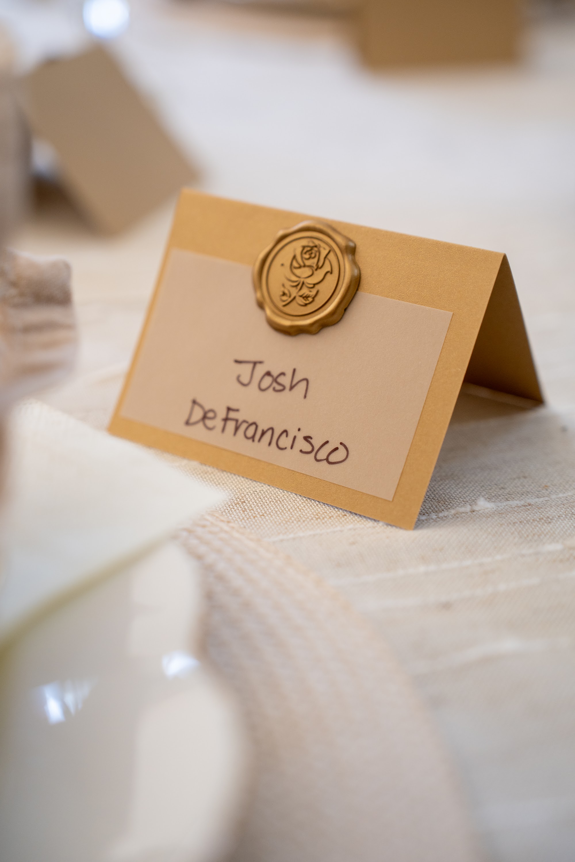 Wax-sealed place card reading Vito Ciambriello at a set table