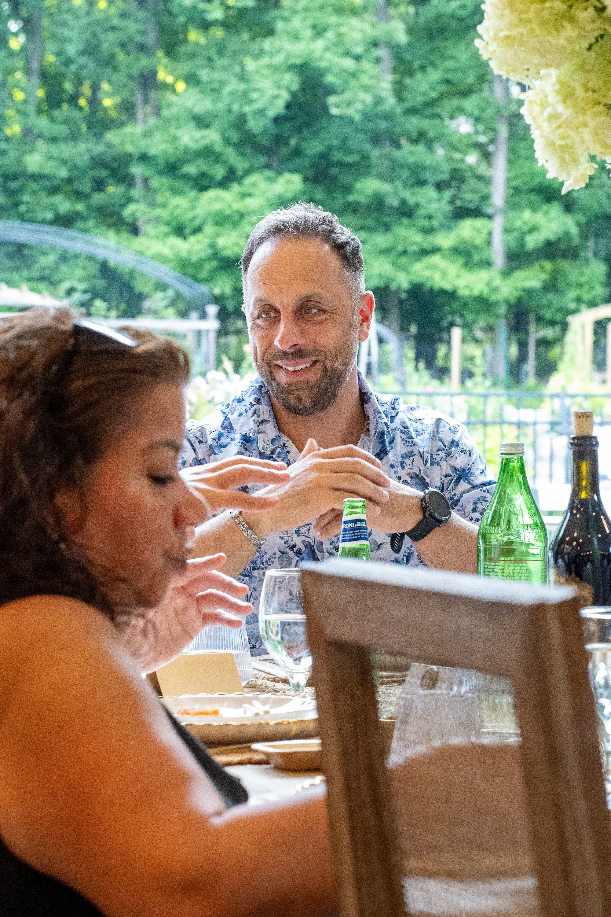 Guest smiling at the outdoor table during the investor dinner