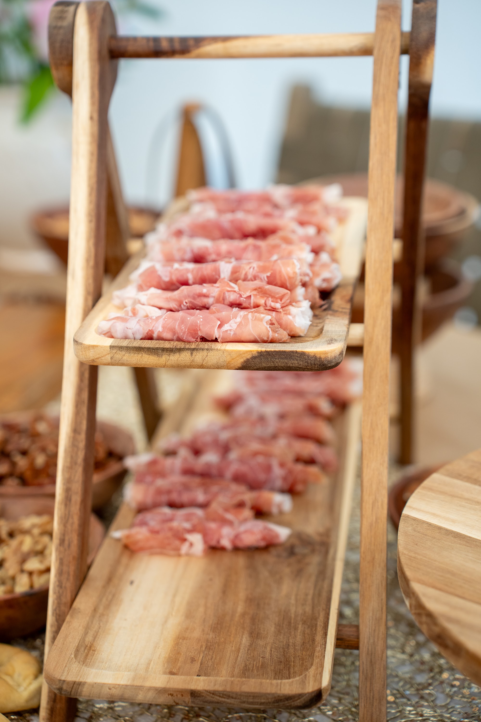 Tiered wooden boards of fresh prosciutto on the buffet