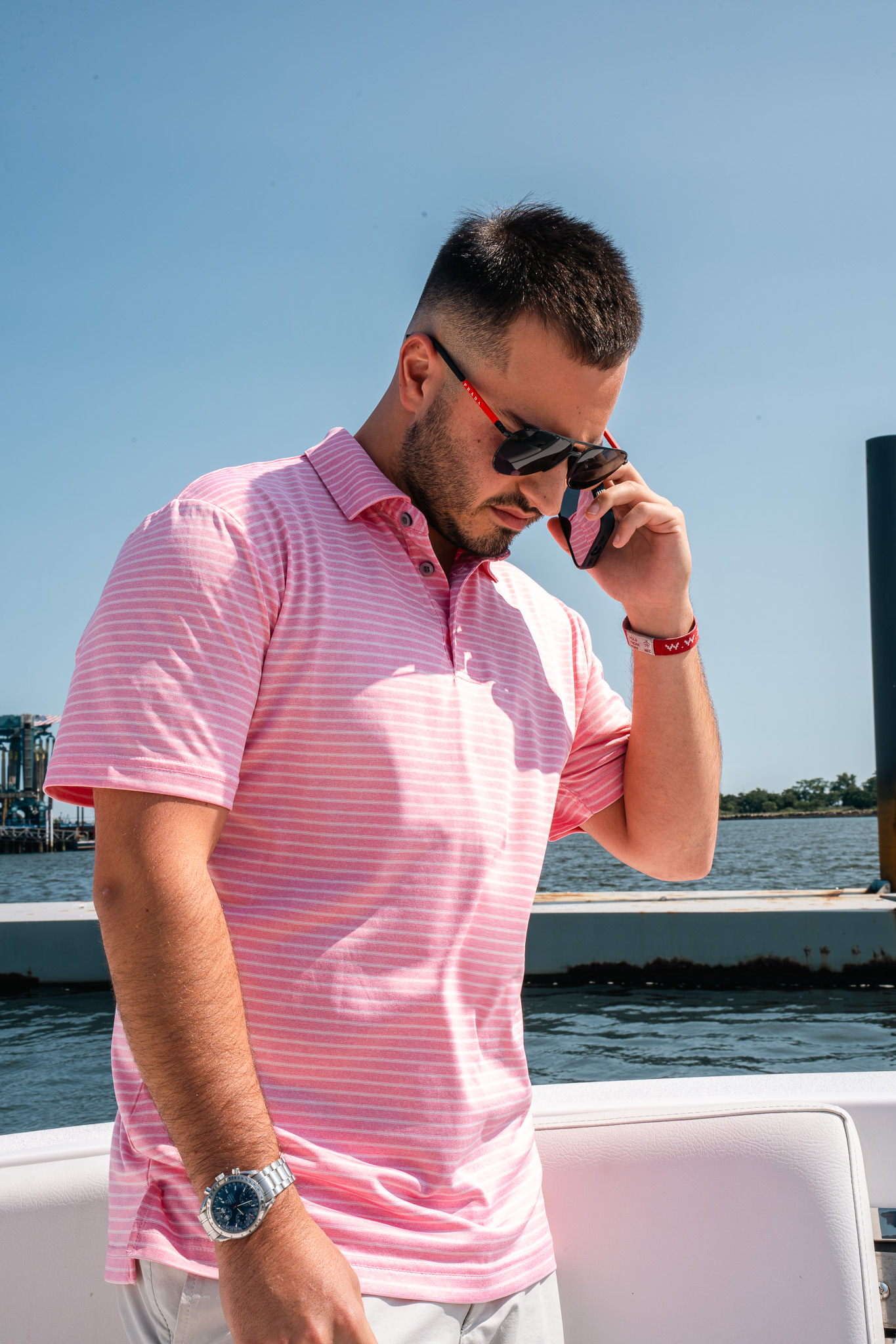 Team member taking a phone call aboard the boat by the dock