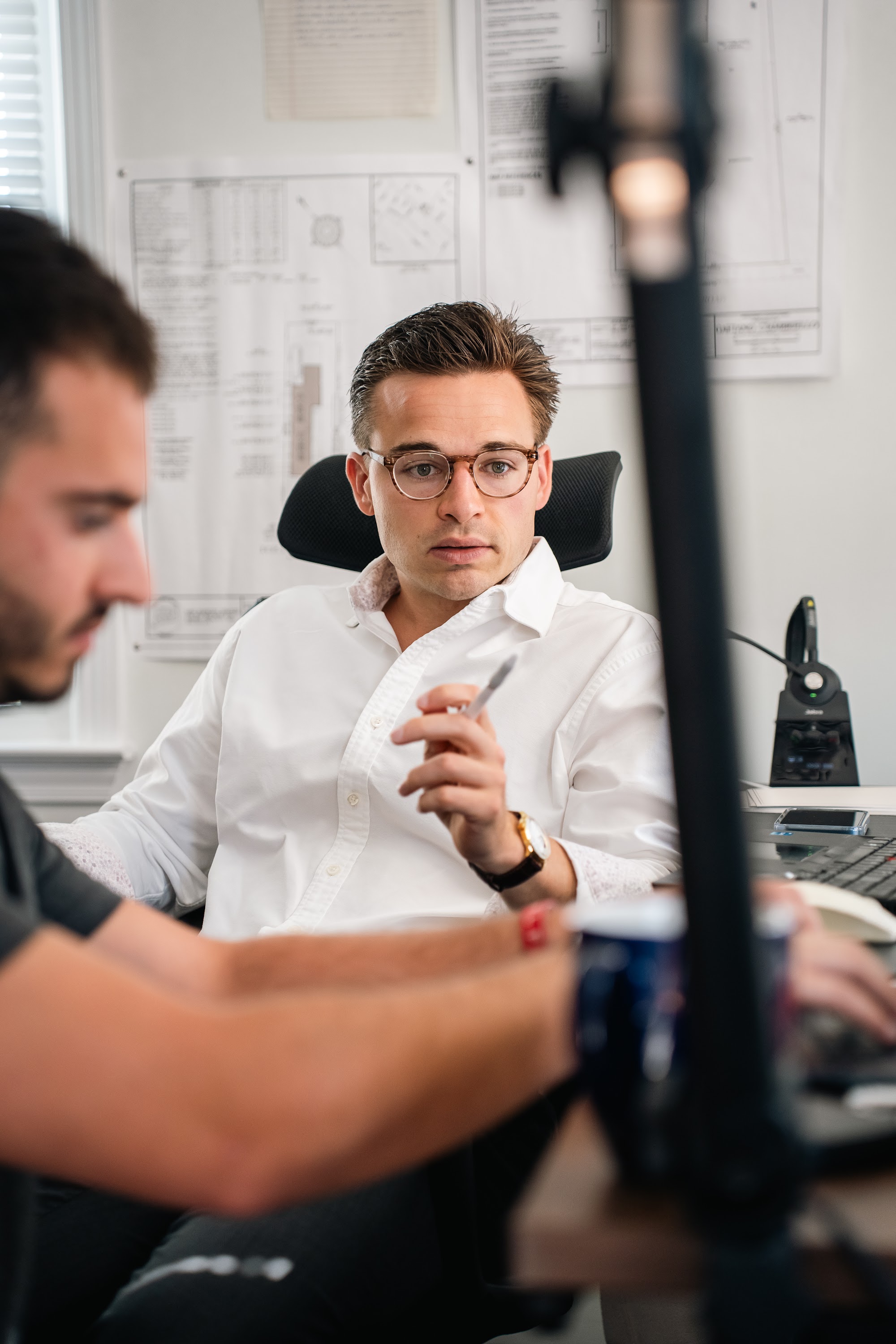 Team member at his desk with pen in hand during the morning huddle