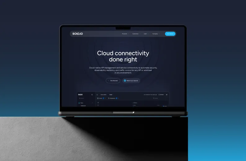Open laptop on edge of concrete surface with dark blue gradient background showing website homepage with headline 'Cloud connectivity done right' and buttons for 'Get Started' and 'Watch our tutorial'.