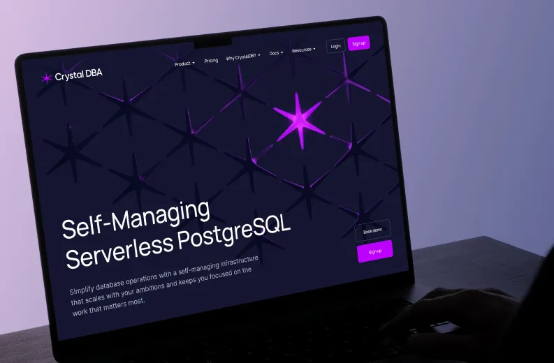 Laptop screen displaying the Crystal DBA website featuring a dark background with purple star graphics and text promoting self-managing serverless PostgreSQL database operations, with navigation links and sign-up buttons visible.