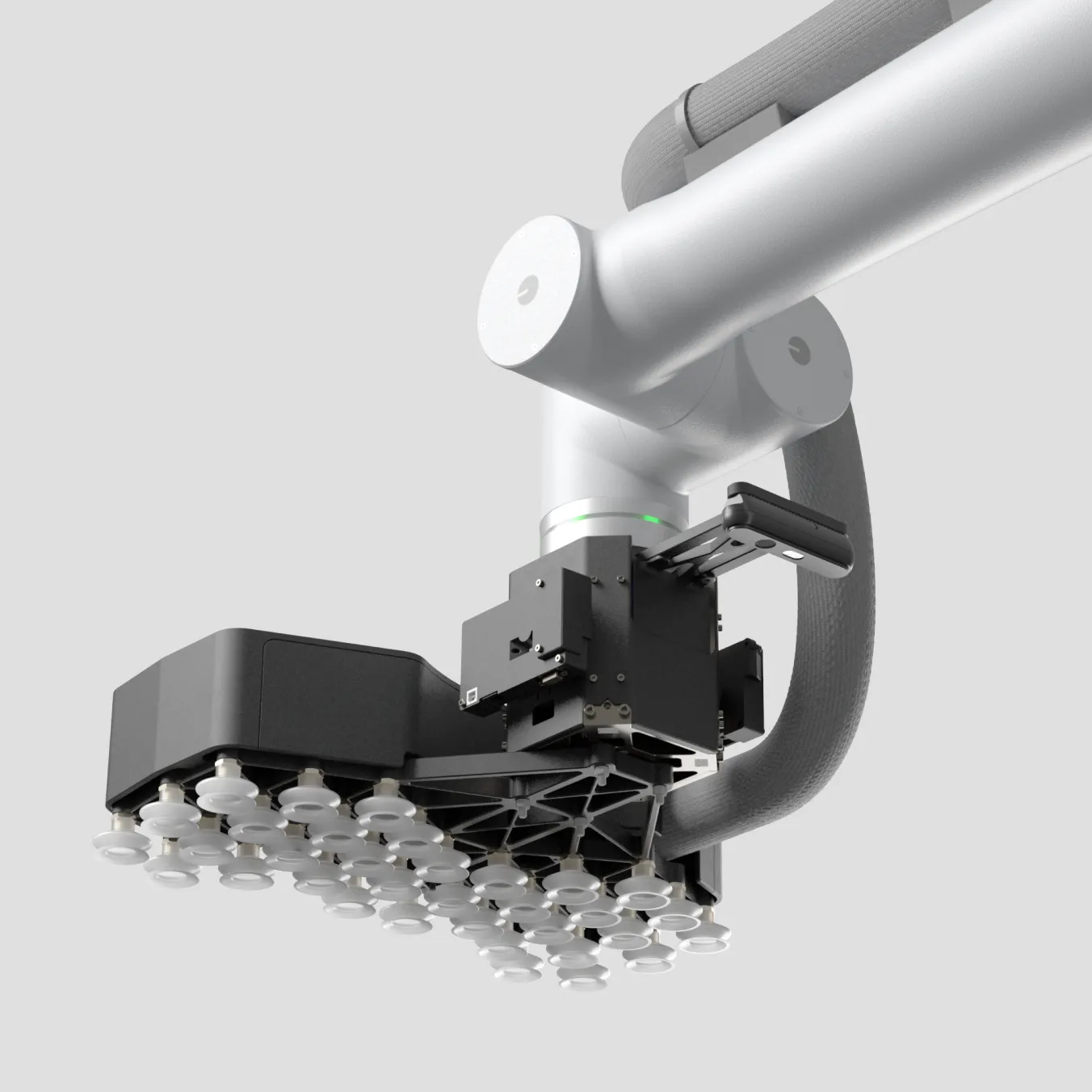 Close-up of a robotic arm with a black end effector featuring multiple white suction cups.