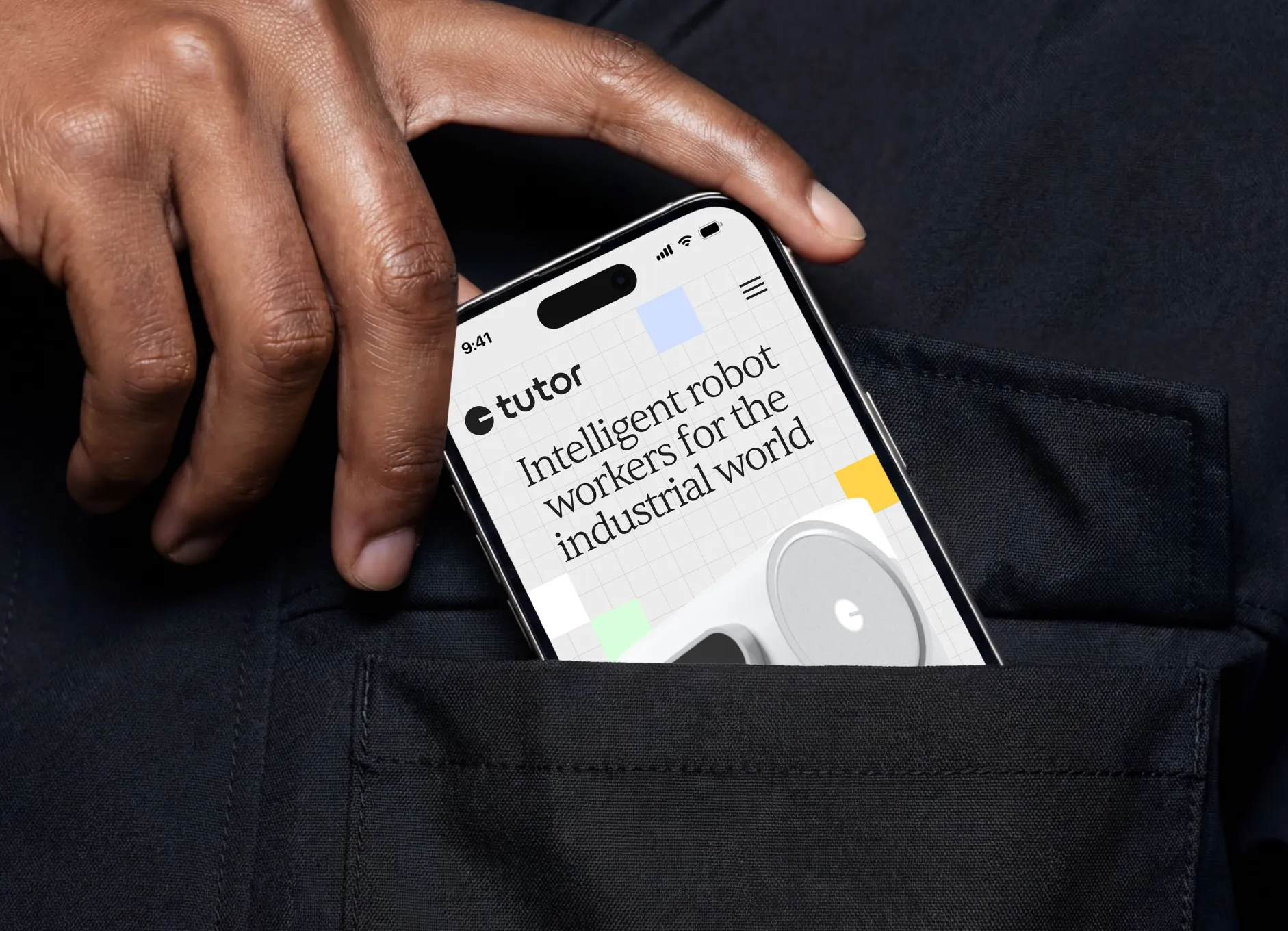 Hand placing phone displaying 'Intelligent robot workers for the industrial world' into a dark pocket.