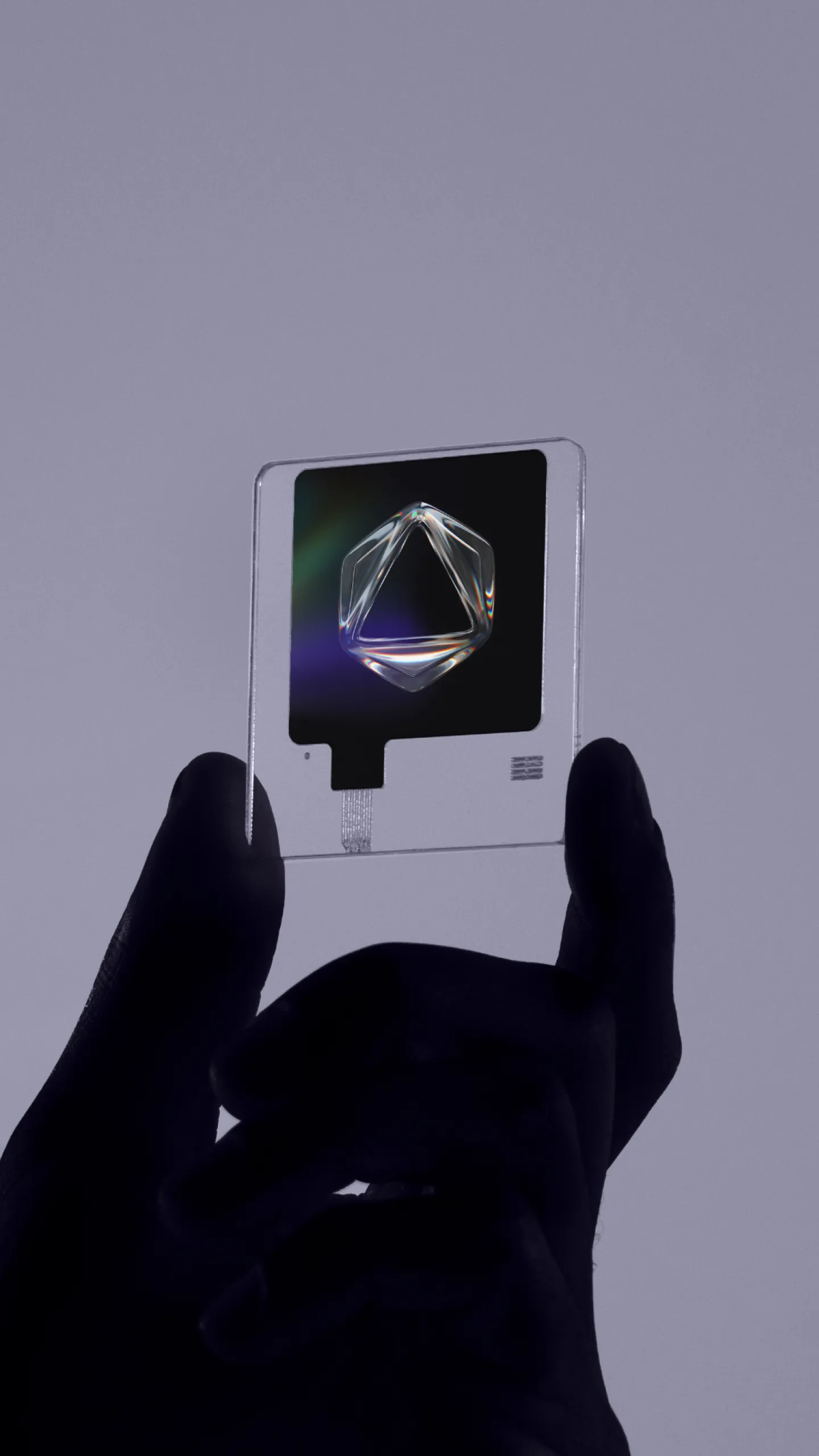 Hand holding a clear acrylic card with a glass crystal shape, part of the Formless brand identity