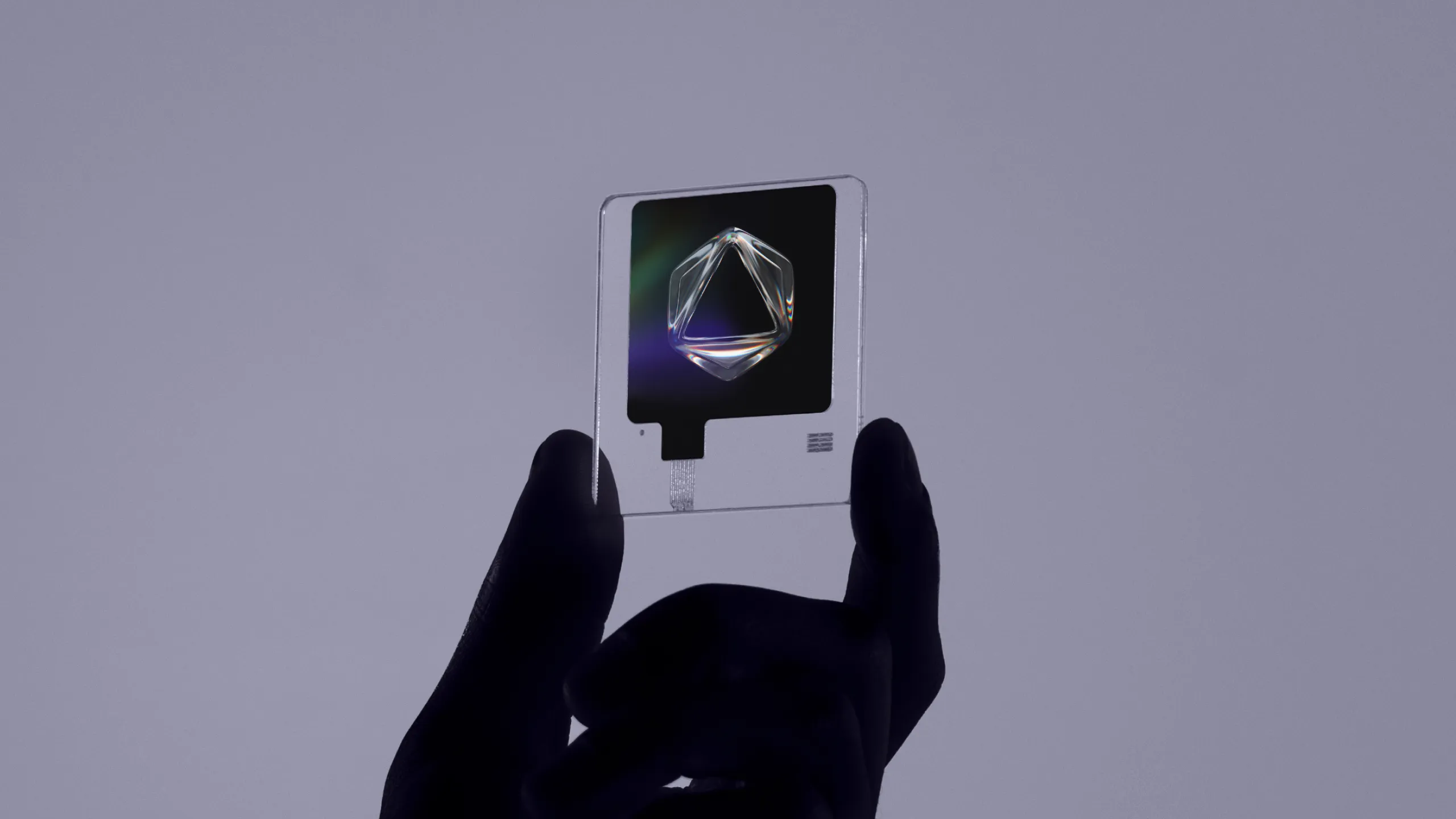Hand holding a clear acrylic card with a glass crystal shape, part of the Formless brand identity