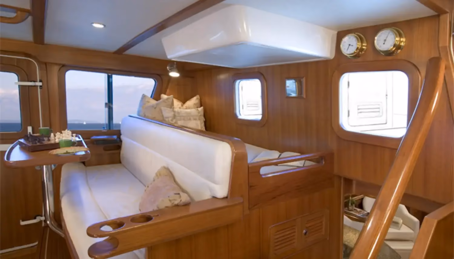 Best practices for yacht cruising include a comfortable interior with wooden finishes, plush seating, and efficient space for relaxation and dining.