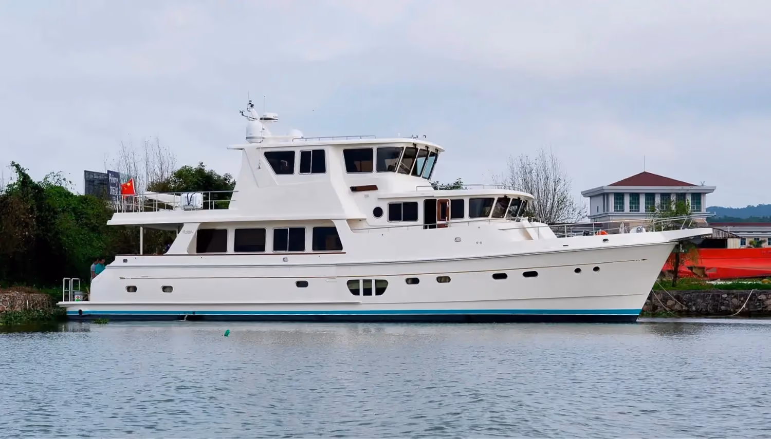 Trawler yachts provide comfort and reliability, as seen in this multi-deck vessel docked near a marina with a sturdy design