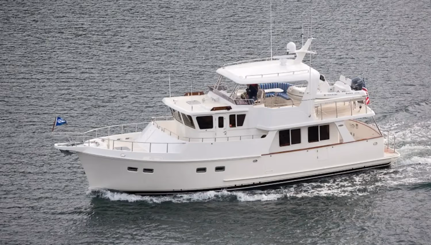 Long-range yachts like this well-equipped trawler are ideal for extended cruising, featuring a flybridge, tender storage, and a spacious layout.