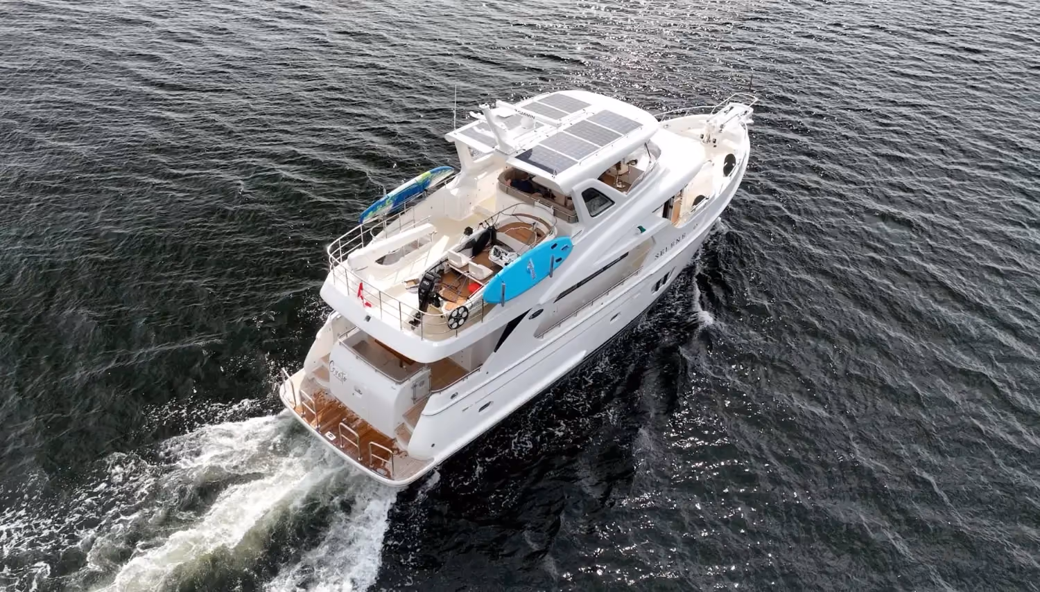 Trawler yacht viewed from above, displaying solar panels, water sports equipment, and a well-equipped deck for long-range cruising.
