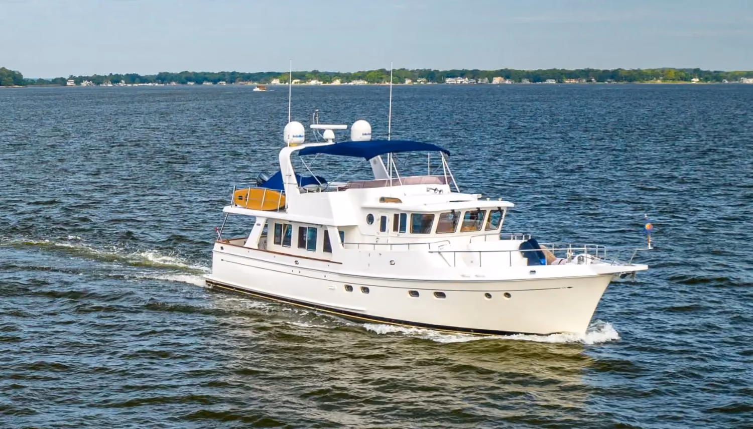Luxury trawler yacht gliding through the ocean, featuring a spacious flybridge, classic design, and comfortable onboard living space