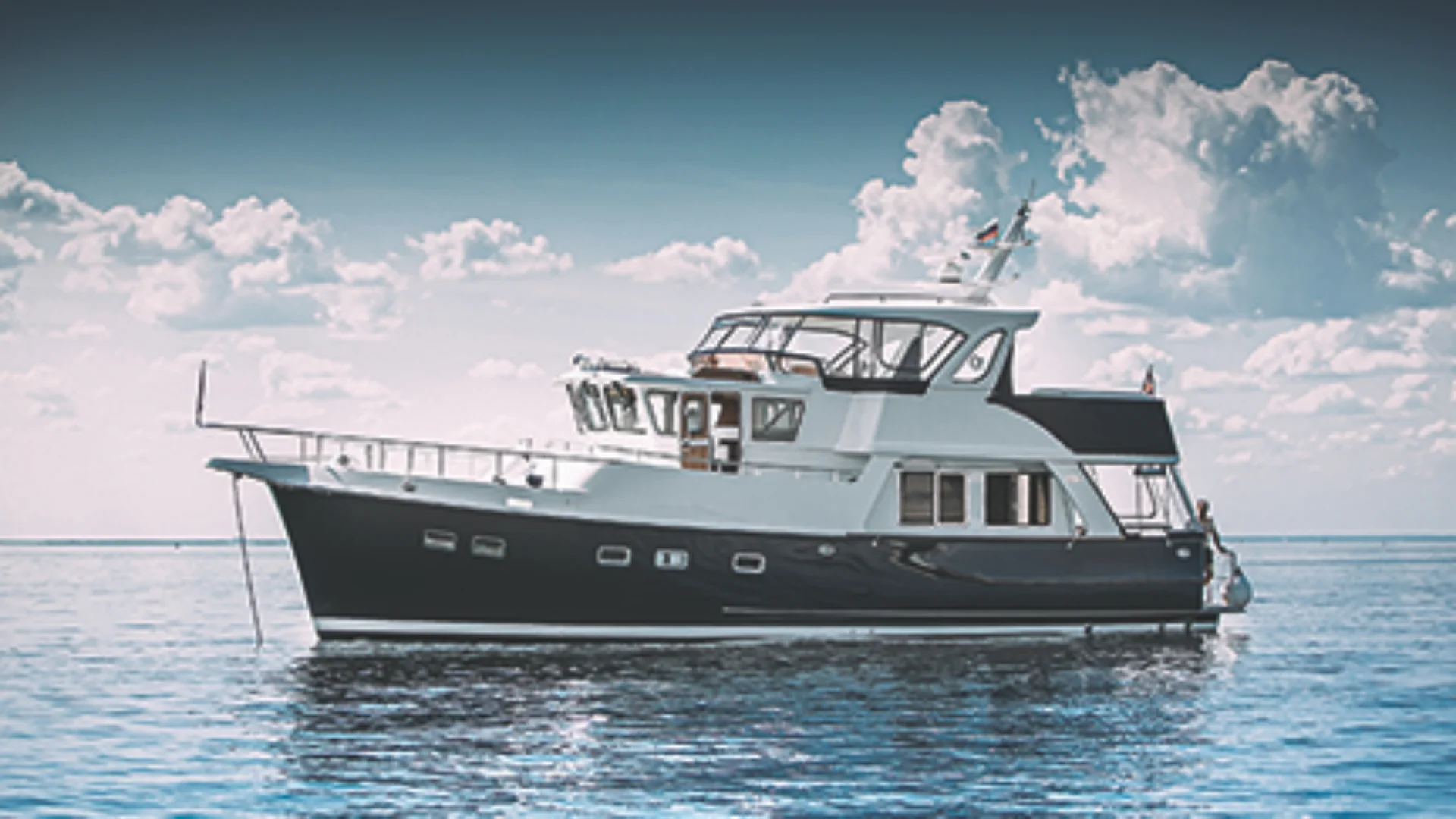 49 classic yacht on calm blue water under cloudy sky