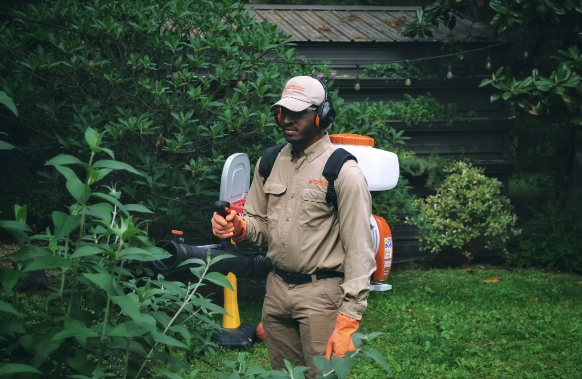 Mosquito control technician treating a residential backyard.