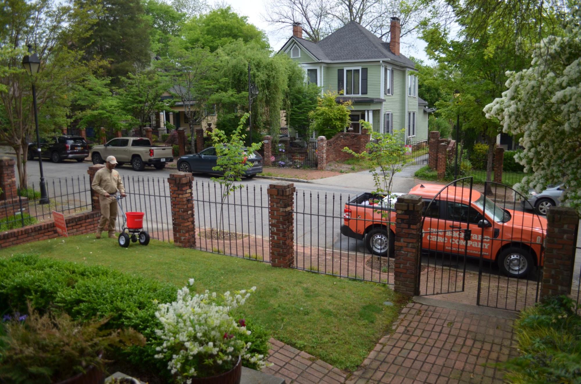 Backyard Care Company technician applying lawn treatment at a residential property in Atlanta.