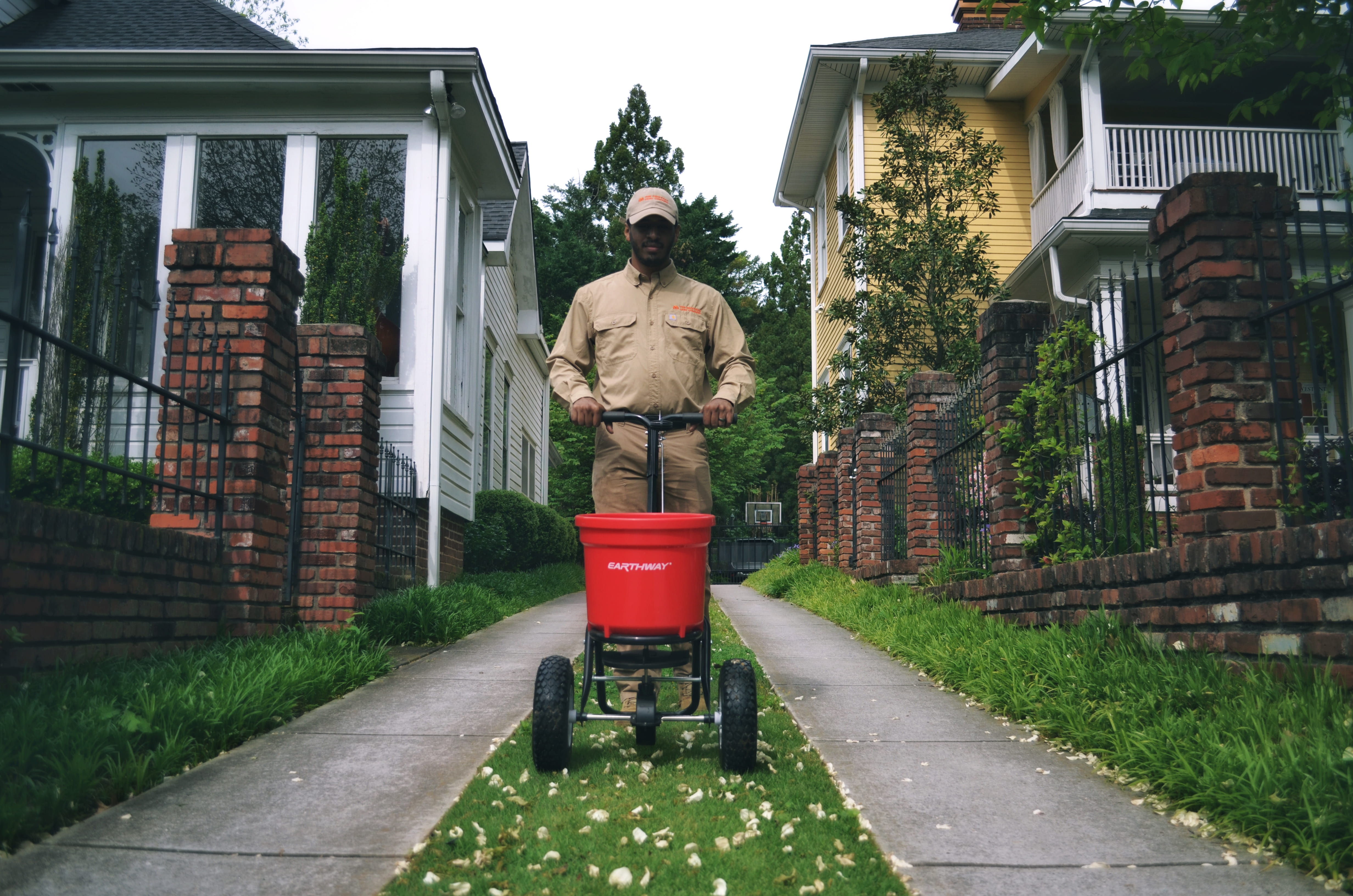 Technician with backpack sprayer in a lush backyard