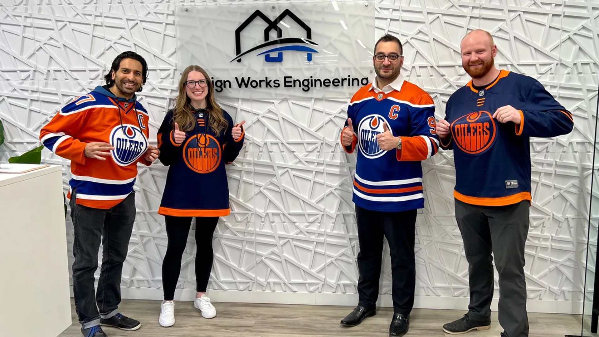 three men and two women in hockey uniforms holding up their thumbs up