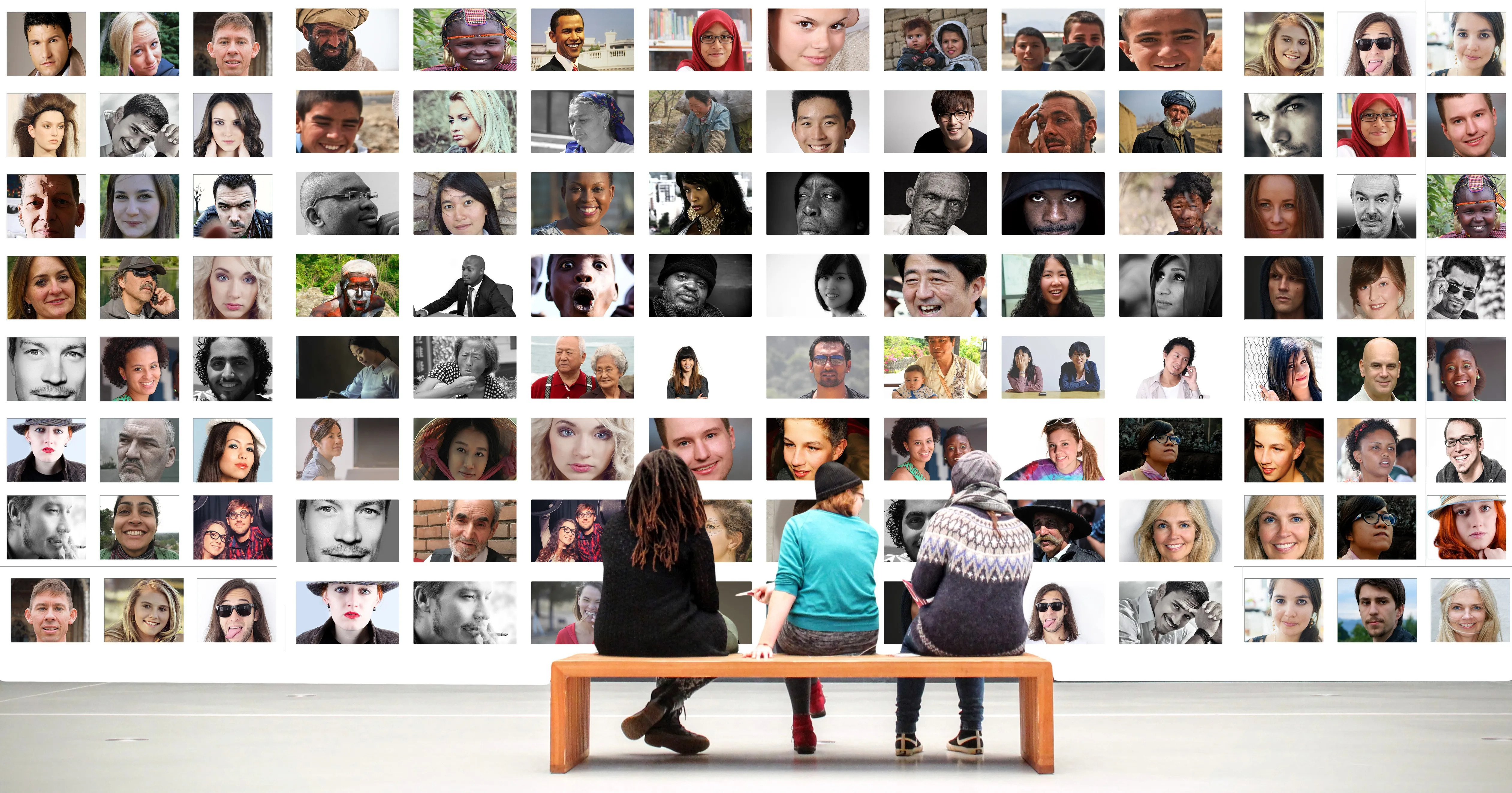 People sitting on bench facing wall of diverse portrait photographs