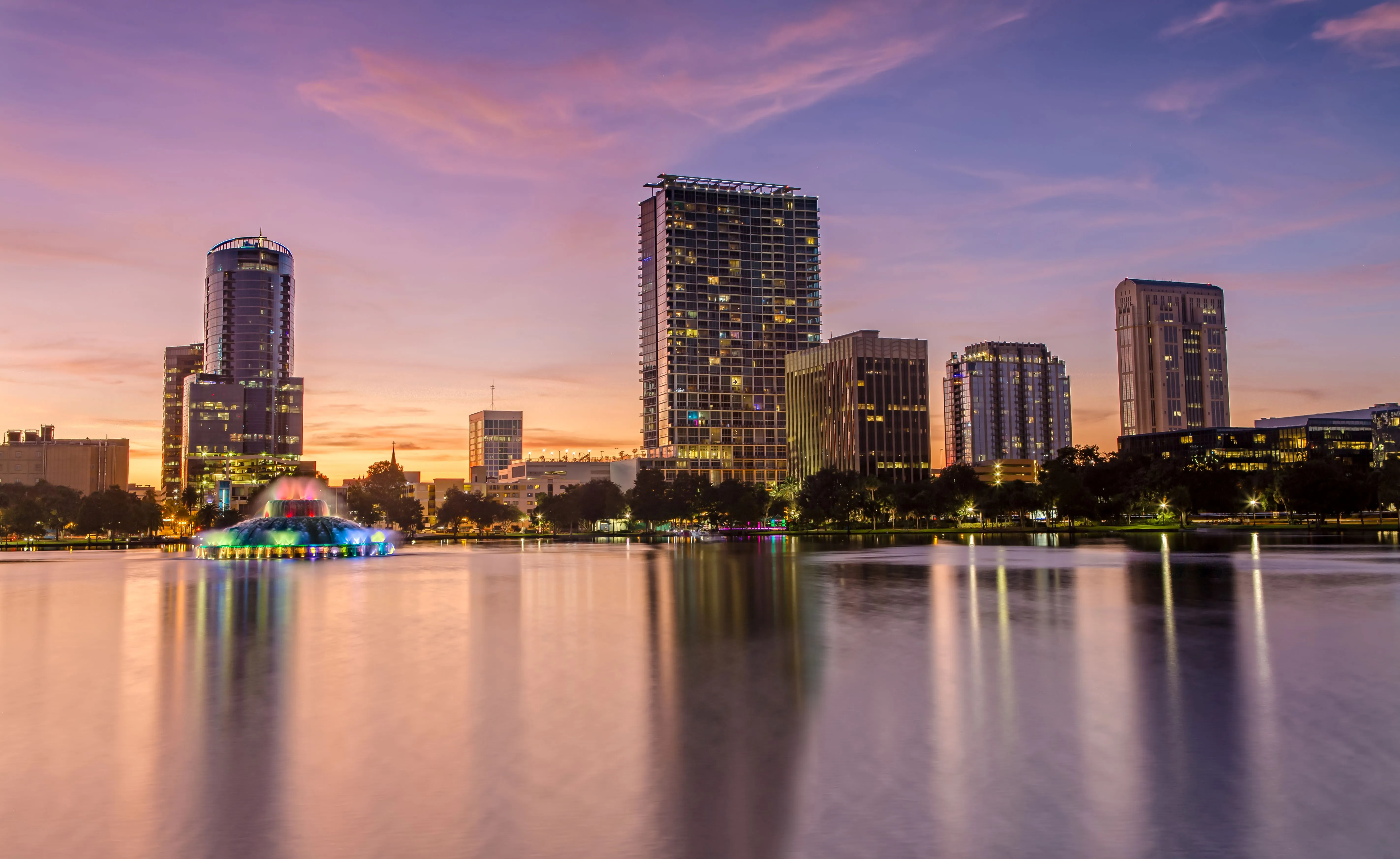 Orlando skyline at sunset with Lake Eola fountain and city reflections