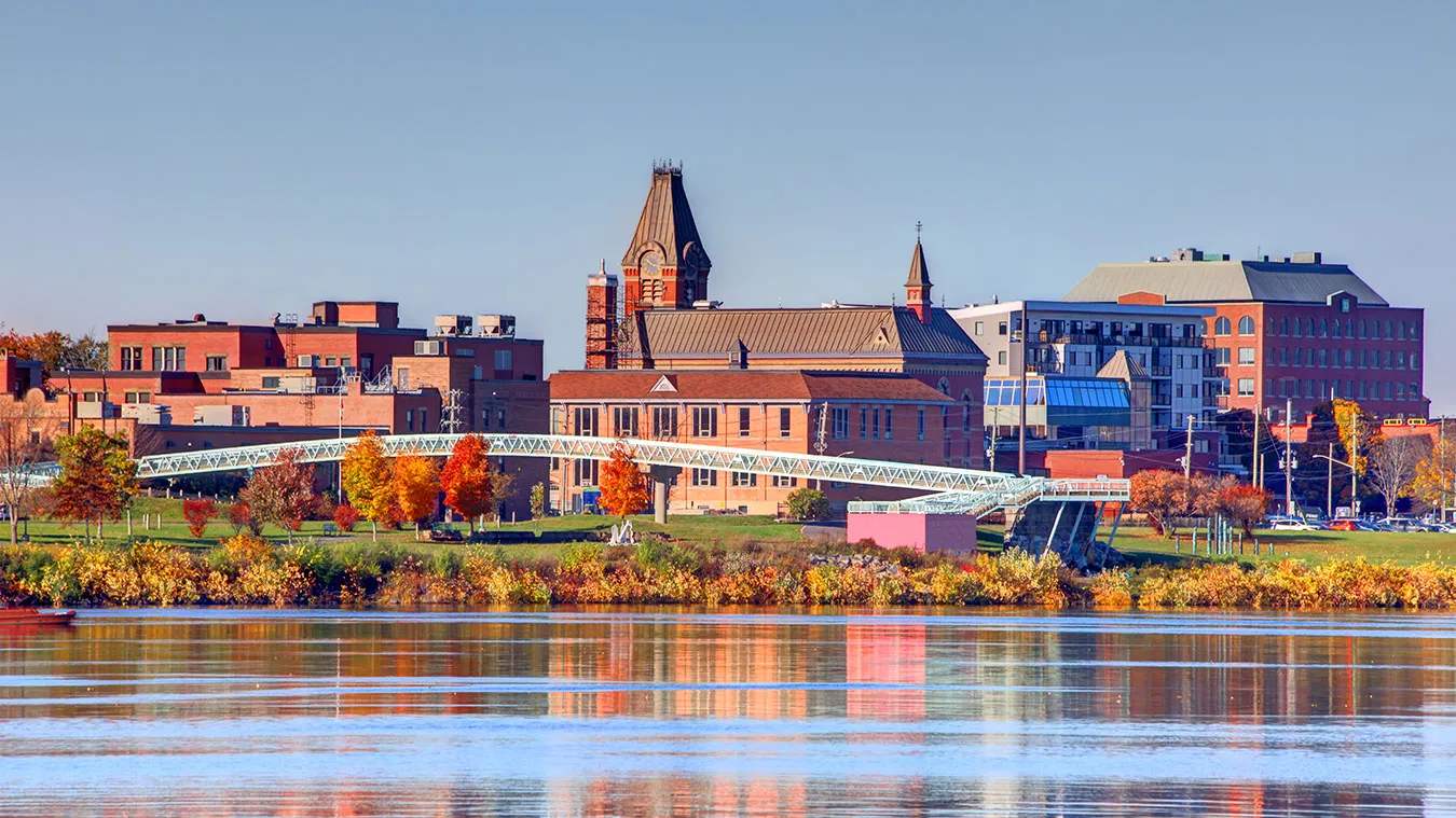 Autumn cityscape with historic buildings reflecting in calm river water