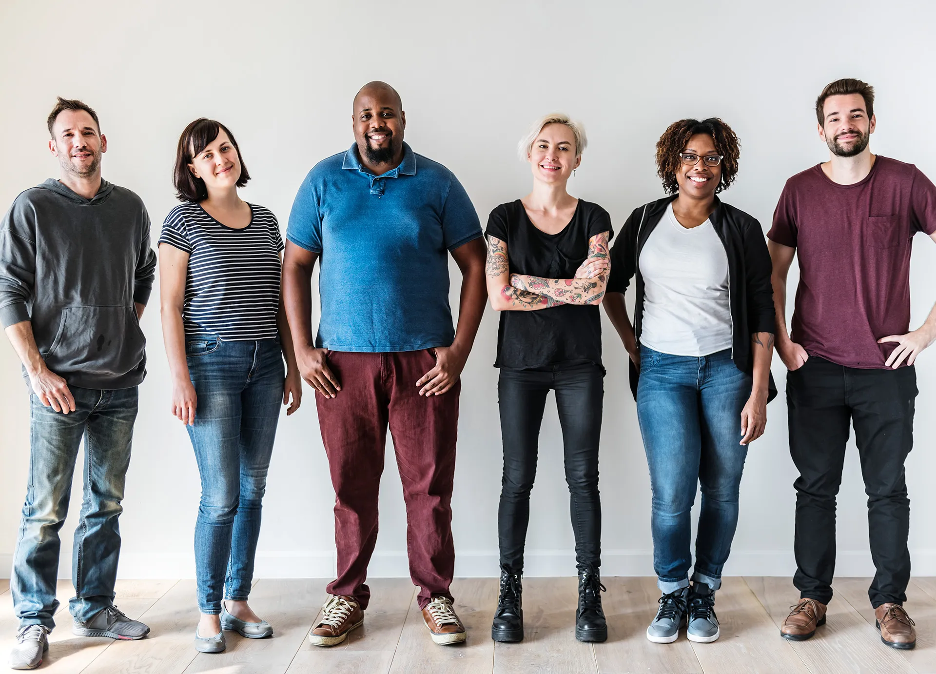 Diverse group of six adults standing together in casual clothing