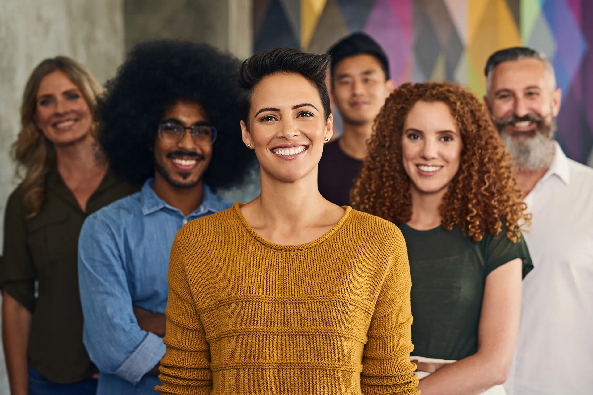 Diverse group of smiling professionals standing together in office