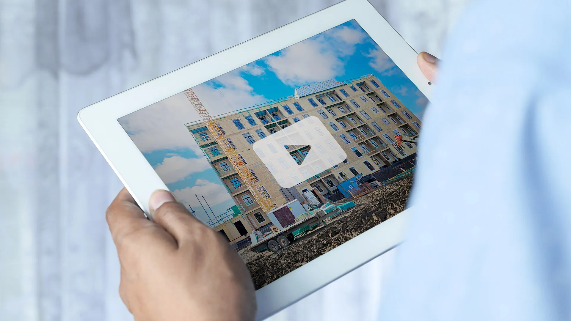 Tablet displaying construction site with multi-story building and crane