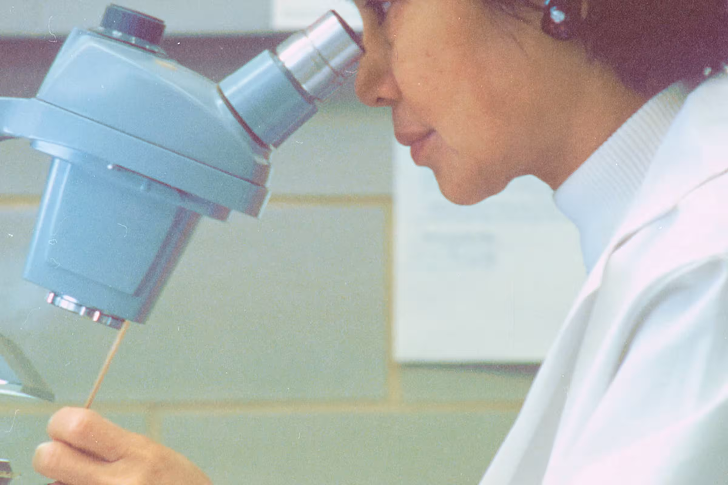 A female scientist examining an STI through a microscope