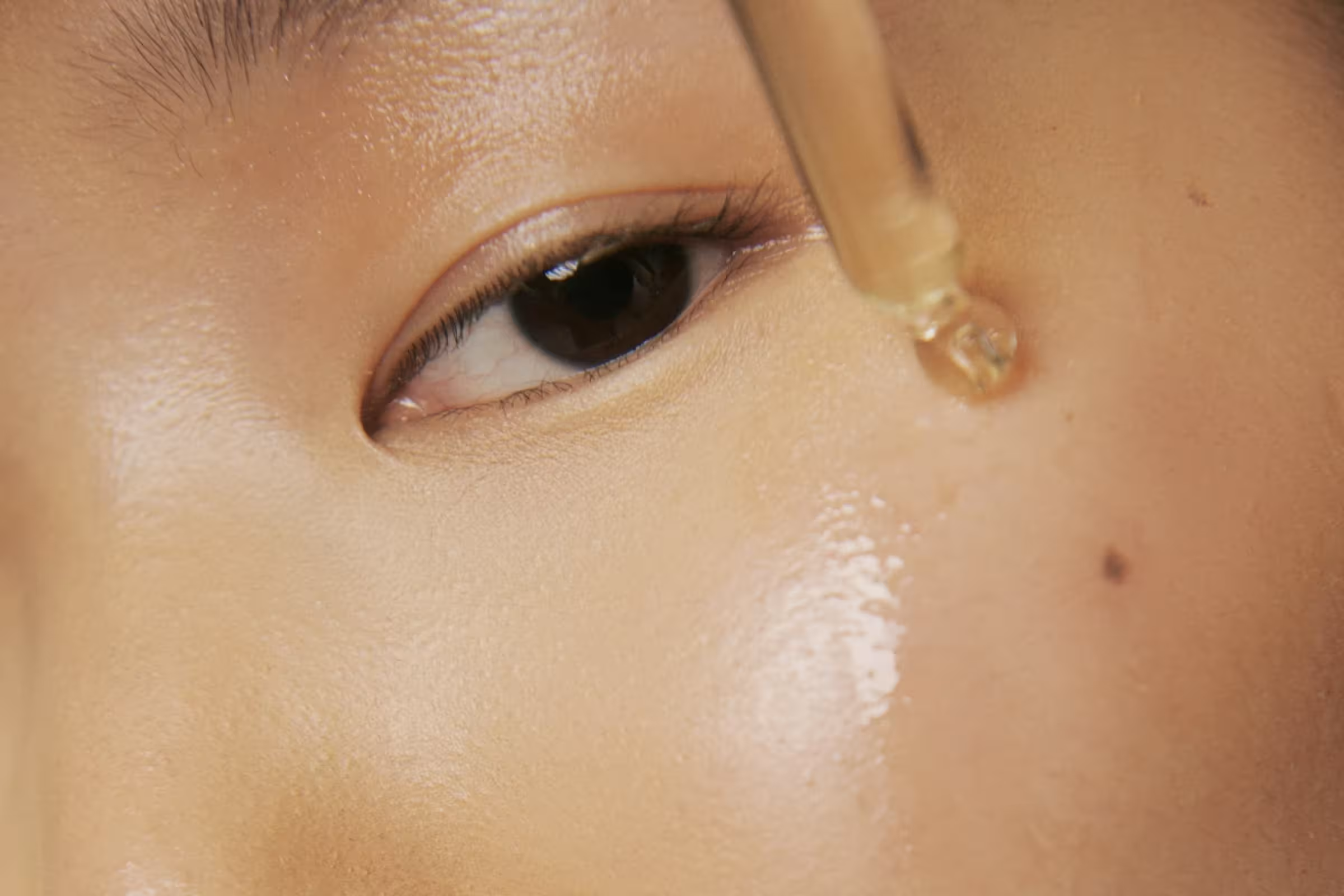 A woman using hyaluronic acid for skincare which can also be used for vaginal dryness.