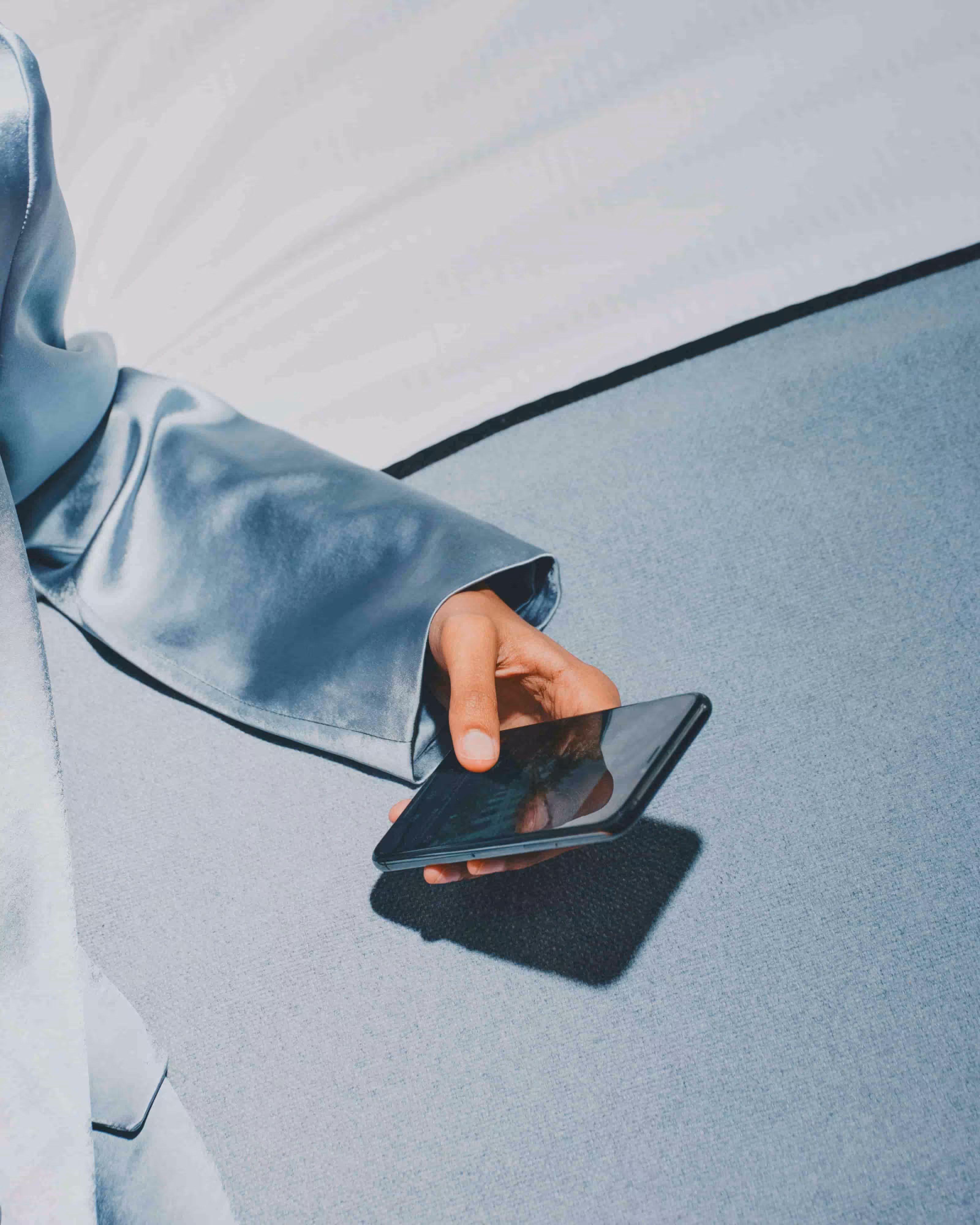 a woman hold a phone with the evvy vaginal symptom tracker spreadsheet pulled up