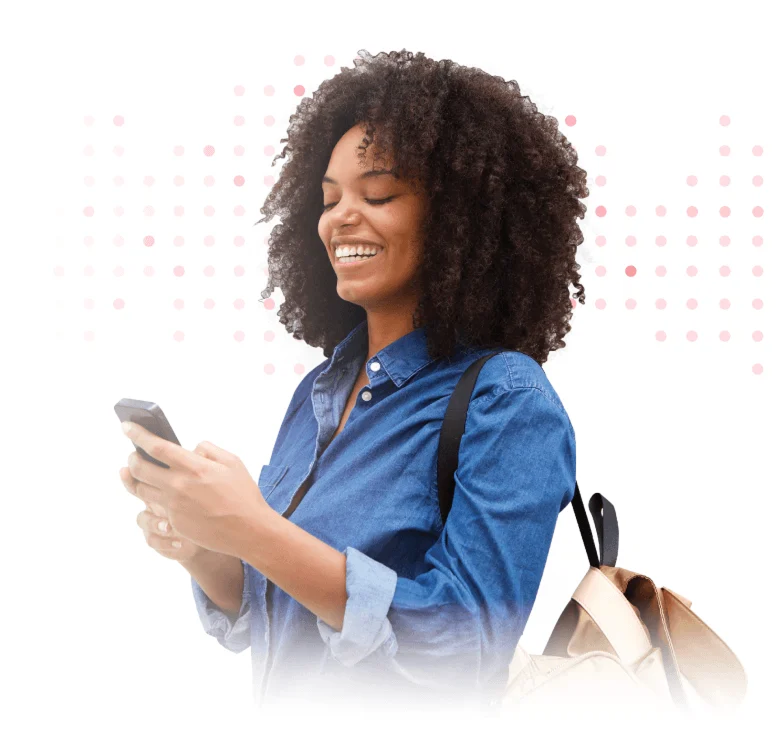 Smiling man in blue shirt looking at smartphone while carrying shoulder bag.