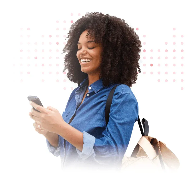 Smiling man in blue shirt looking at smartphone while carrying shoulder bag.