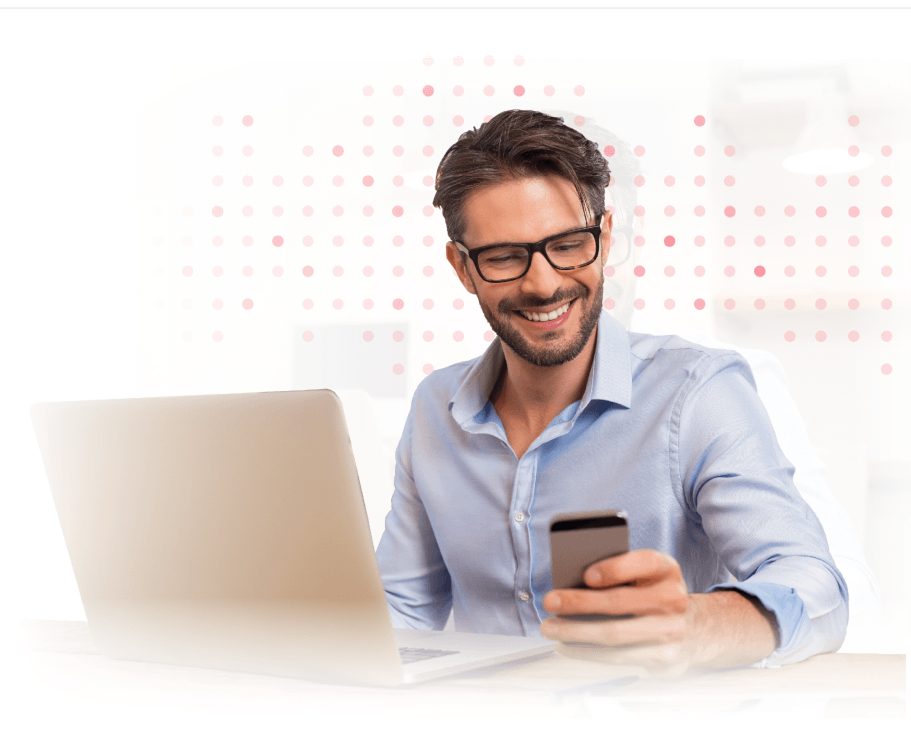 Smiling man in blue shirt looking at smartphone while carrying shoulder bag.