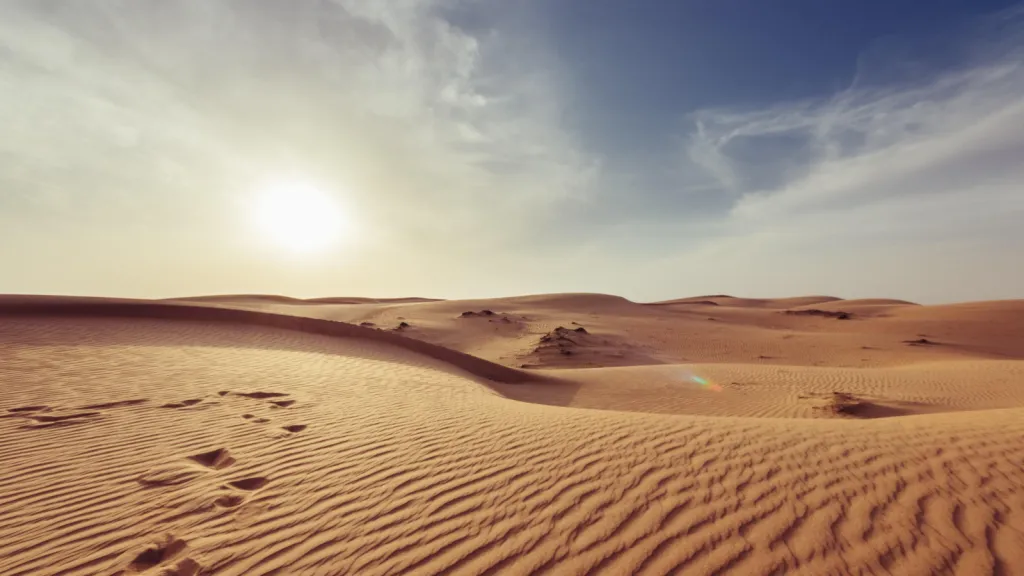 footprints that are in the sand with some sky