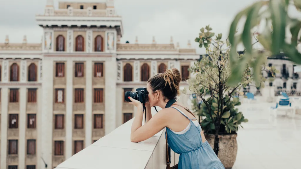a woman taking photos with her camera of a city
