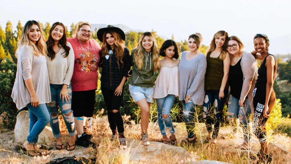 several girls are standing outside in the grass