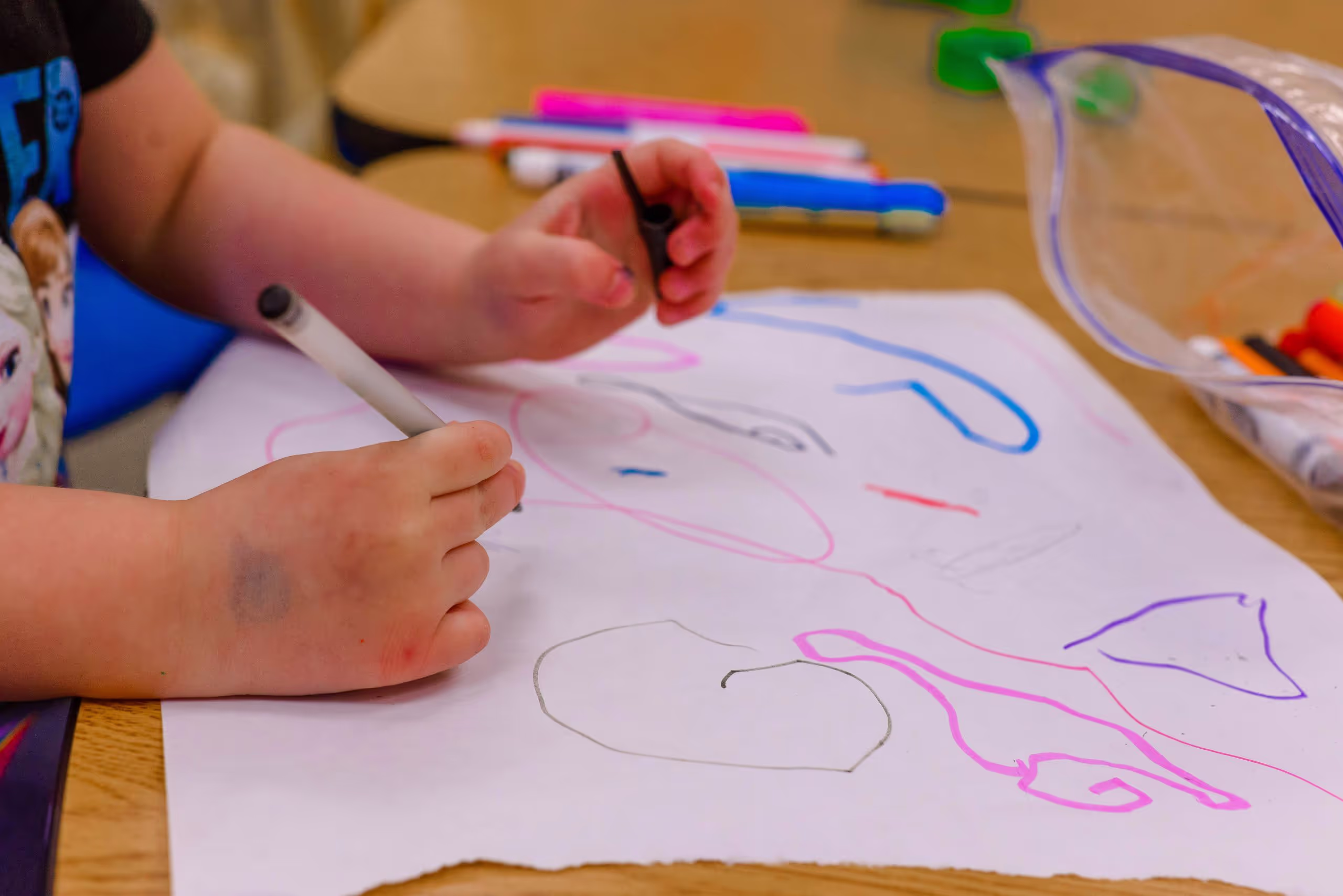 A preschool student drawing at a co-op preschool
