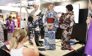 着物を着てポーズを取る3人とスマホで写真を撮る女性。