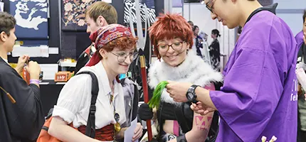 コスプレ衣装を着た参加者たちがイベントで交流している様子。