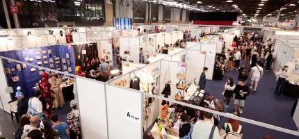 多くの人々が商品を見るためにブースが並ぶ屋内展示会場の眺め。