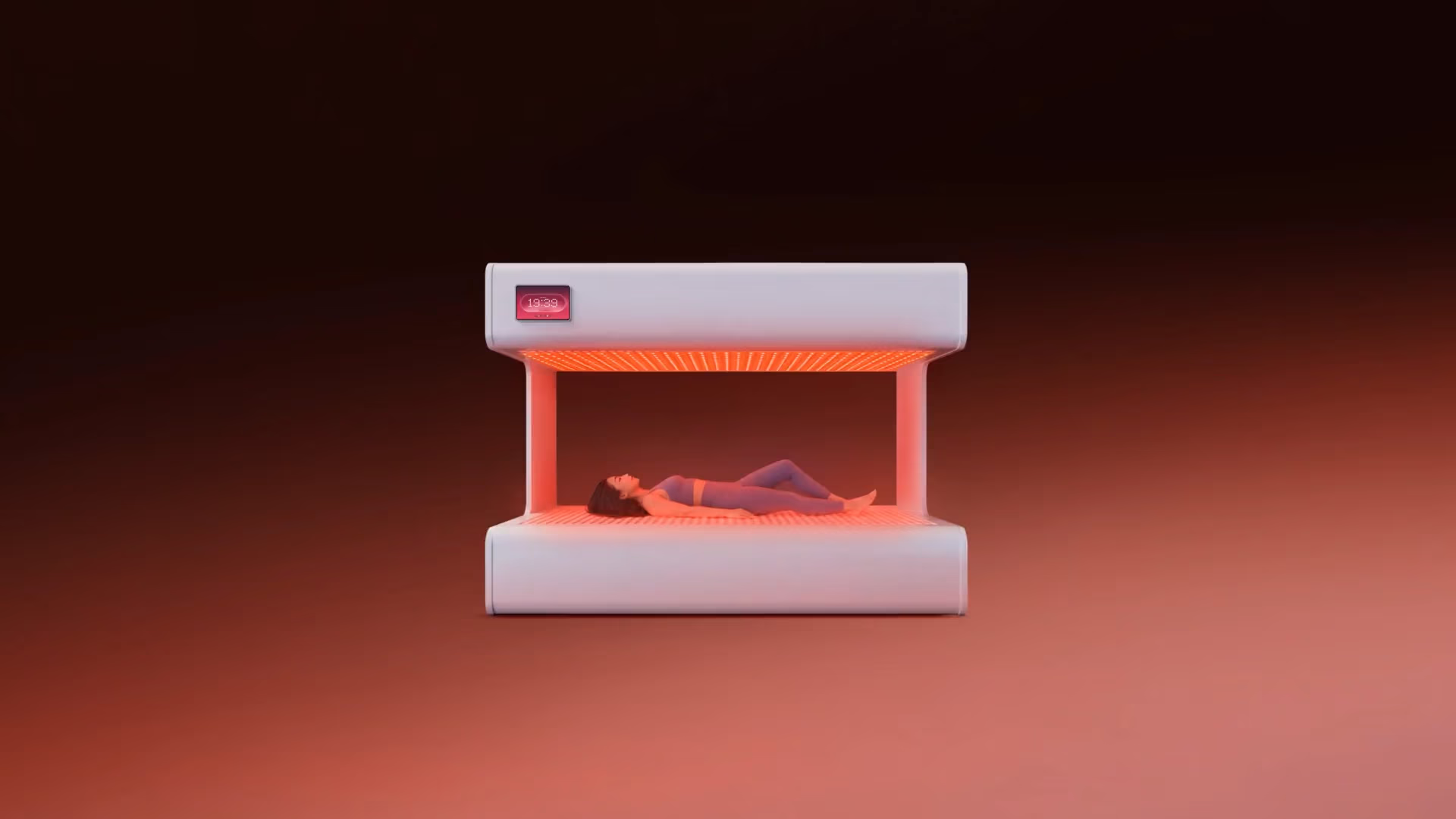 Woman lying inside a white futuristic device emitting red light around her body.