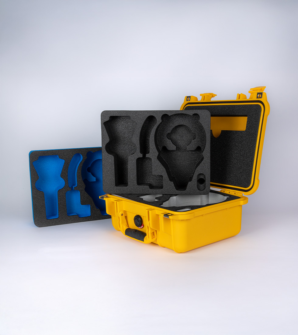 Yellow Peli Protector case with layered custom foam inserts showcasing precision-cut cavities for specialist equipment