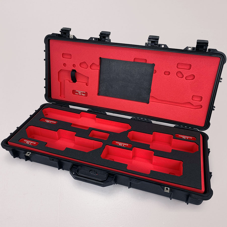 Custom-cut red and black foam insert in flight case designed for aerospace components by MSA Foams.