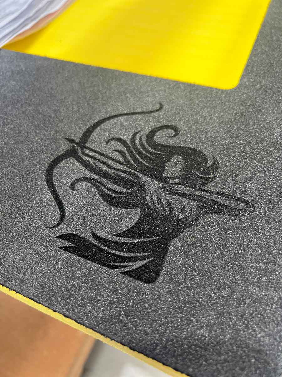 Close-up of black and yellow foam insert with detailed laser engraved archery logo for equipment protection and branding